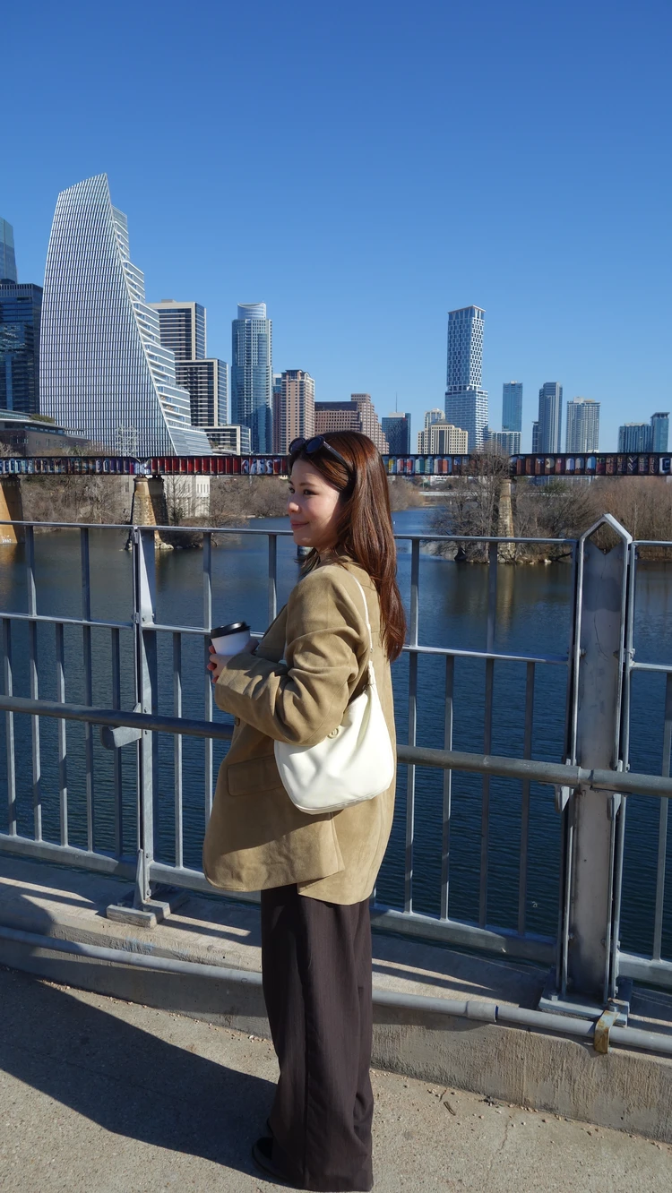 Gentle Monsterのブラウンサングラスを合わせたジャケットコーデ。オースティンのレディ・バード湖に架かるプフルーガー・ペデストリアン・ブリッジにて。