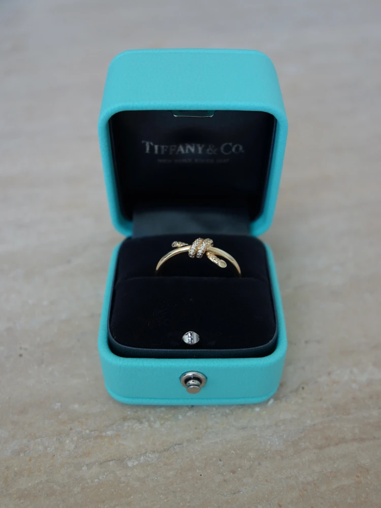 ティファニーブルーのボックスに入った、イエローゴールドとダイヤモンドのTiffany Knot(ティファニーノット)リング