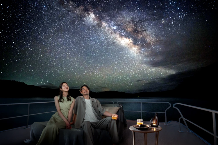 360度星空に囲まれた船上で食後酒とともに星空を観賞する様子