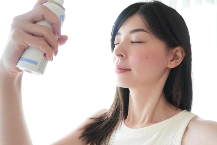顔に吹きかけている写真