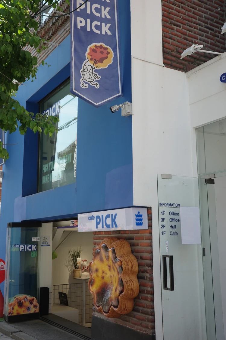 PICK BAKEの青を基調とした外観、店頭の大きなエッグタルトのオブジェ