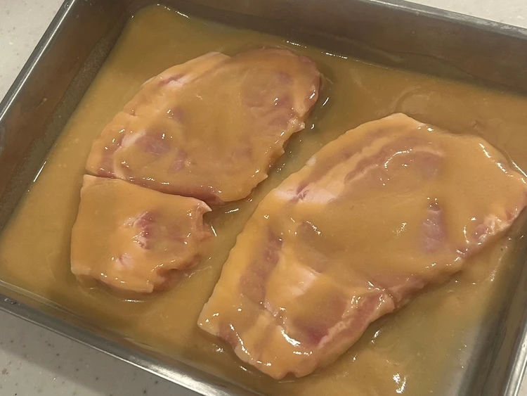 トレイにのった豚ロース肉２枚に無印良品の「かんたん調理　粕漬け焼きの素」が塗られている