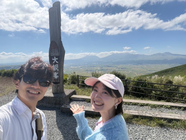 大観峰で写真を撮るカップル 熊本旅行におすすめの観光スポット「大観峰」。熊本県阿蘇市の観光。カルデラと阿蘇の山。阿蘇ミルク 熊本旅行 熊本復興支援 くまもと旅行 熊本観光スポット 熊本おすすめ 九州旅行 九州観光