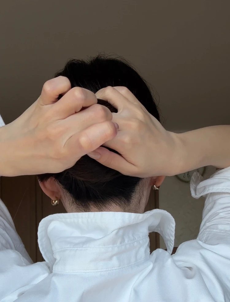 Uピンで根元の髪をすくい、引っかけているフレンチツイストの手順