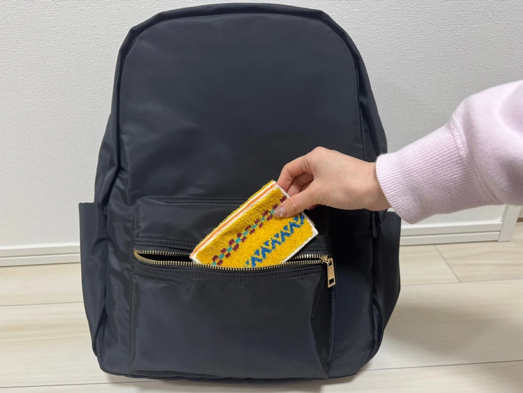 通勤リュック　高機能リュック　リュックの外ポケットにハンカチを入れる様子　UNITED ARROWS green label relaxing おすすめ通勤バッグ