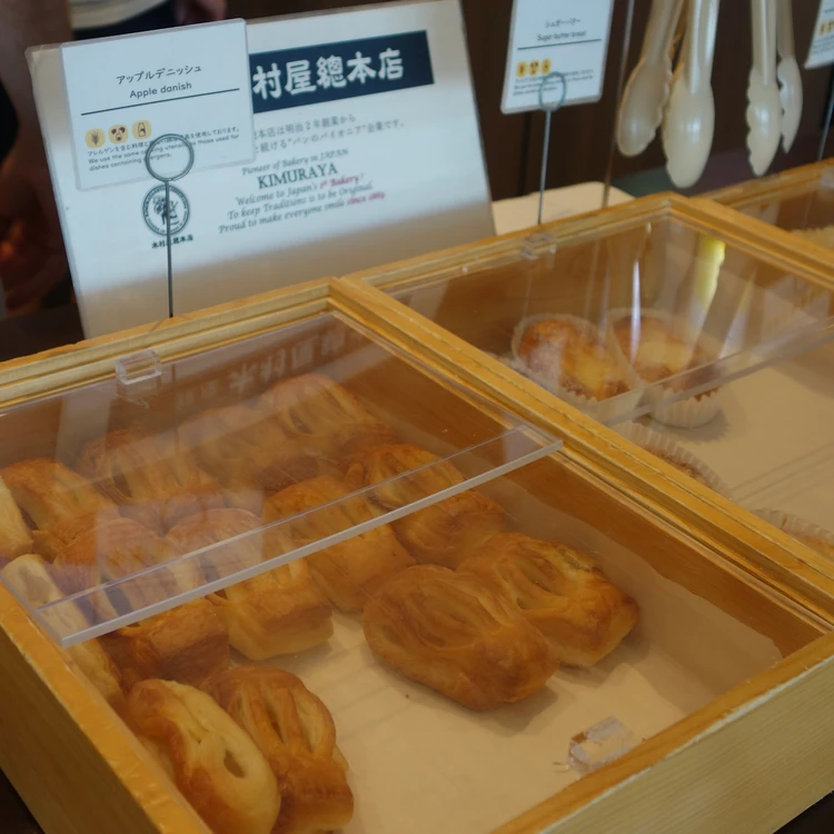 木村屋總本店のアップルデニッシュなど各種パンが並ぶケース⁠