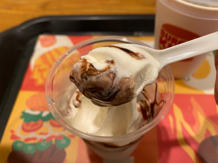 ソフトクリームをスプーンで持ち上げている