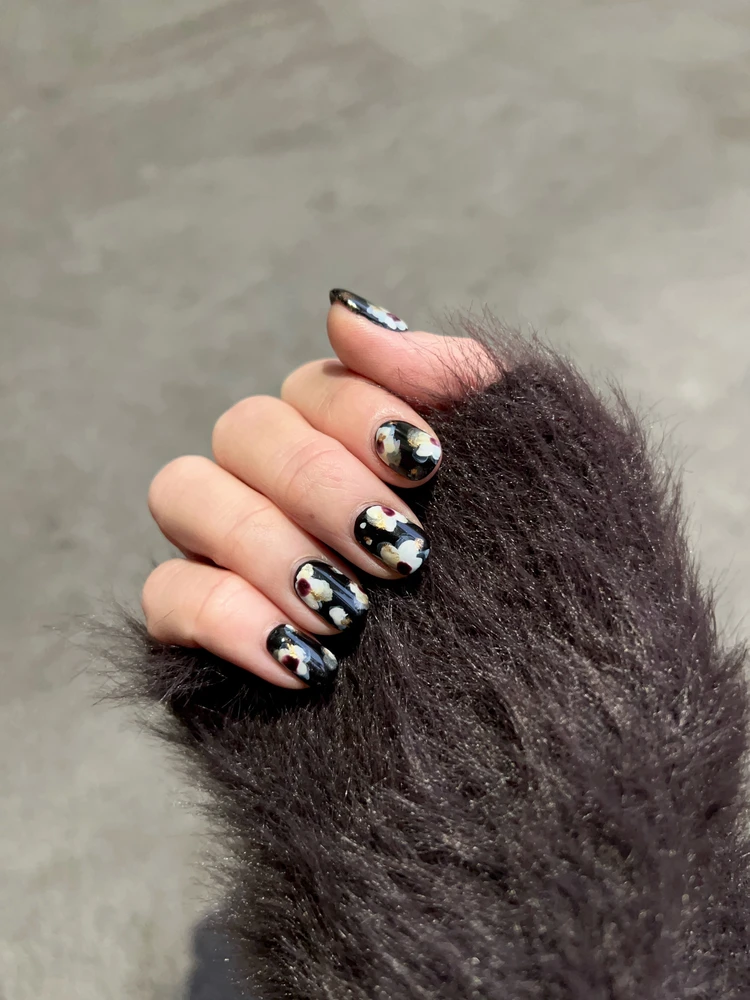 ブラックベースに花柄アートを施した大人の冬ネイル。ちぐはぐネイル。