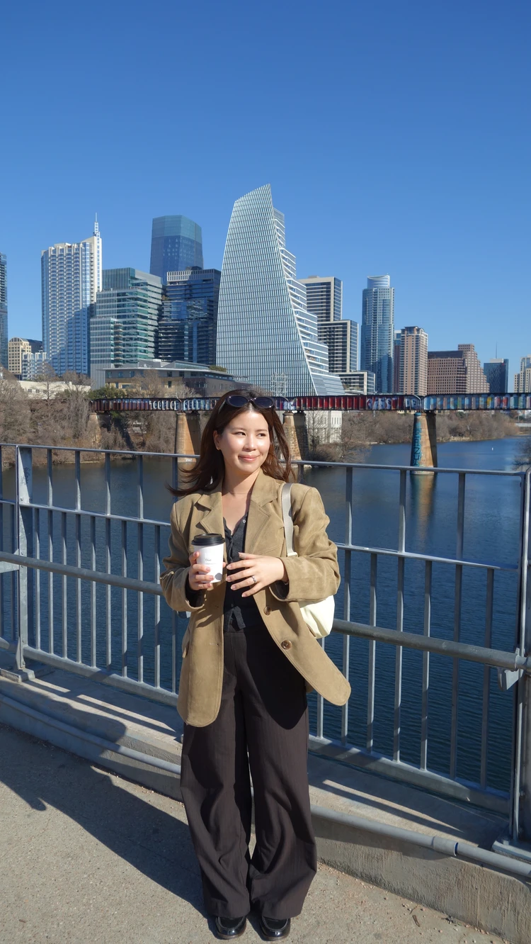 Gentle Monsterのブラウンサングラスを合わせたジャケットコーデ。オースティンのレディ・バード湖に架かるプフルーガー・ペデストリアン・ブリッジにて。