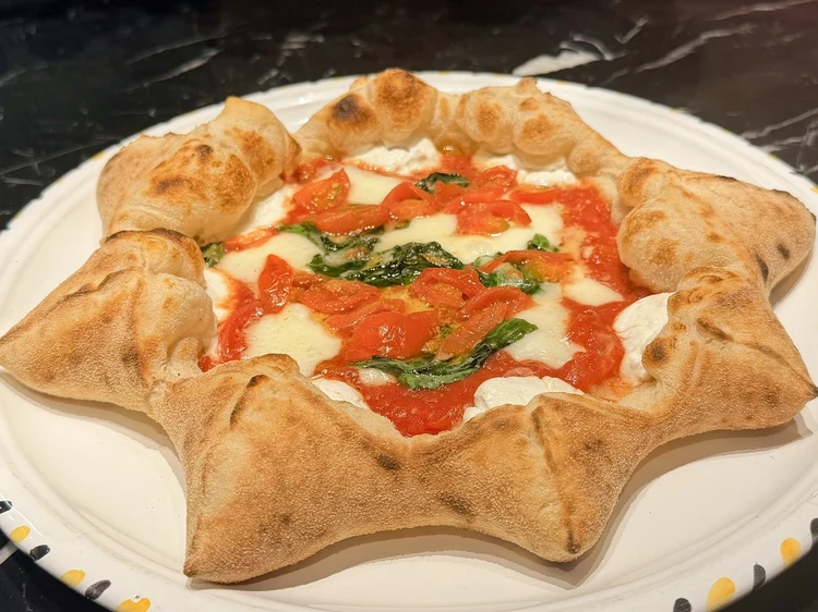 麻布台ヒルズの「リストピッツァ バイ ナポリスタカ」の名物、星型ピッツァ「ドン・サルヴォ」。耳の部分にチーズとスパイシーなサラミを包み込んだ、アジア1位の実力を誇る華やかな一枚。