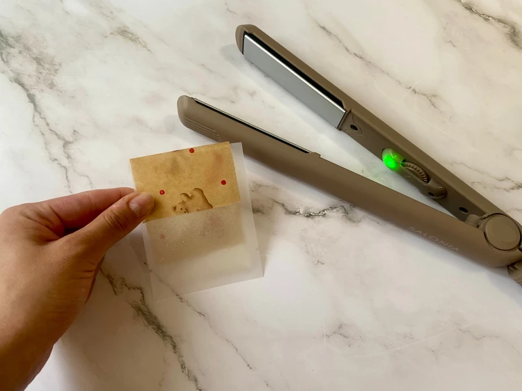 クッキンシートをパウチの口に当て、ヘアアイロンを当てる