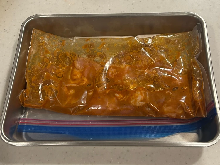 ビリヤニソースに浸かった鶏もも肉がジップロックに入っている