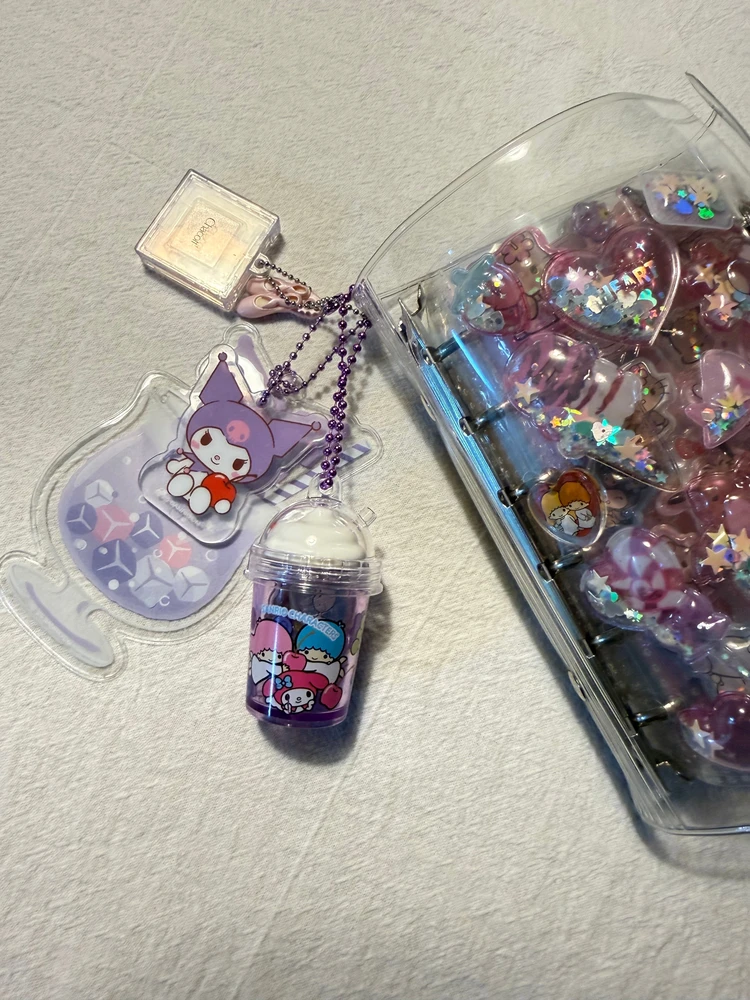 シール帳に小物入れやガチャガチャのキーホルダーをつけた写真