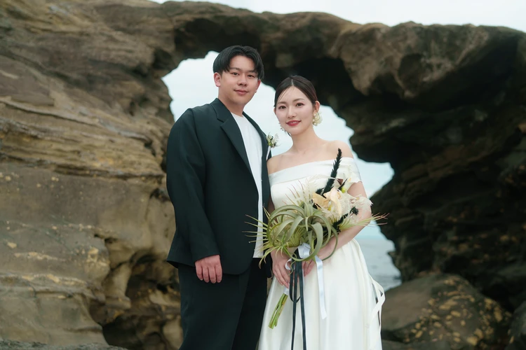 城ヶ島の馬の背洞門を背景に立つ新郎新婦