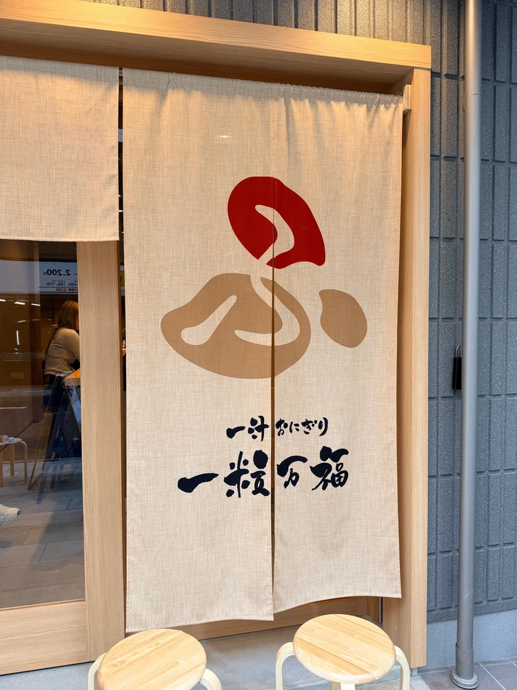 新宿御苑前駅の出口すぐにある「一粒万福」の店舗外観。木目調のおしゃれで清潔感のあるおにぎり専門店。