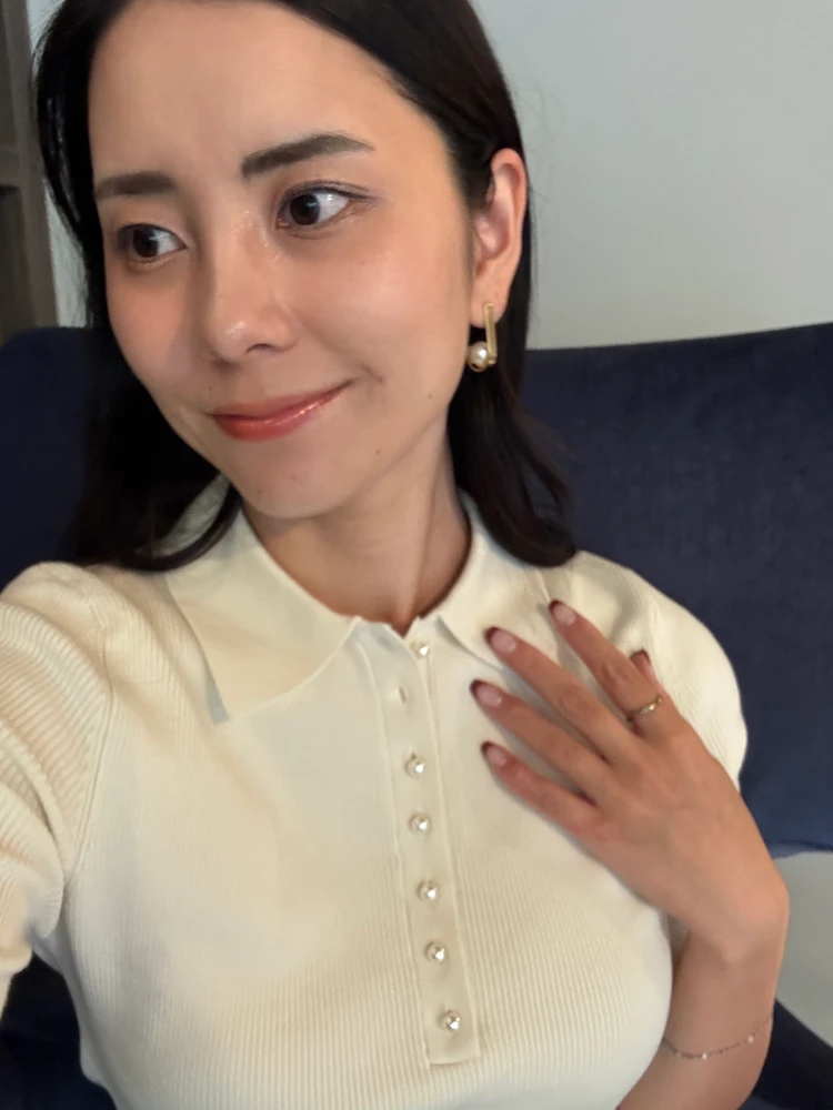 ミラオーウェンのシルクブレンドパール釦ポロニット着用した女性の写真