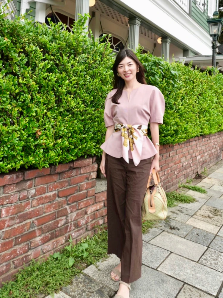 ZARAのピンクペプラムトップスに同系色のスカーフをウエスト巻きし、ブラウンパンツを合わせたコーデ
