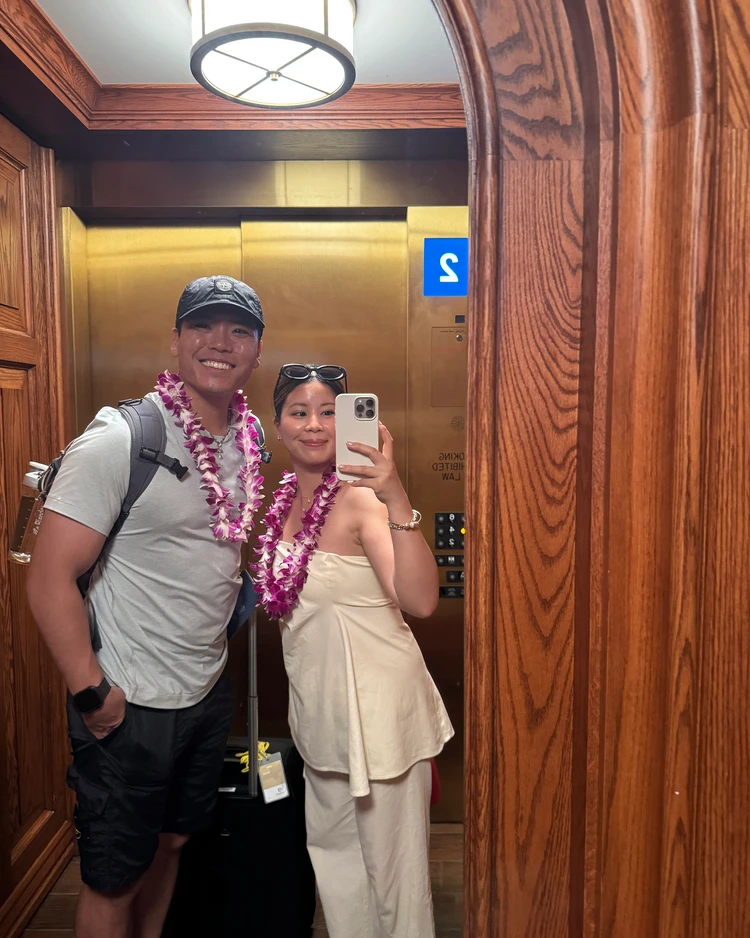 モアナサーフライダーのエレベーターでレイを身につけた夫婦のミラーショット