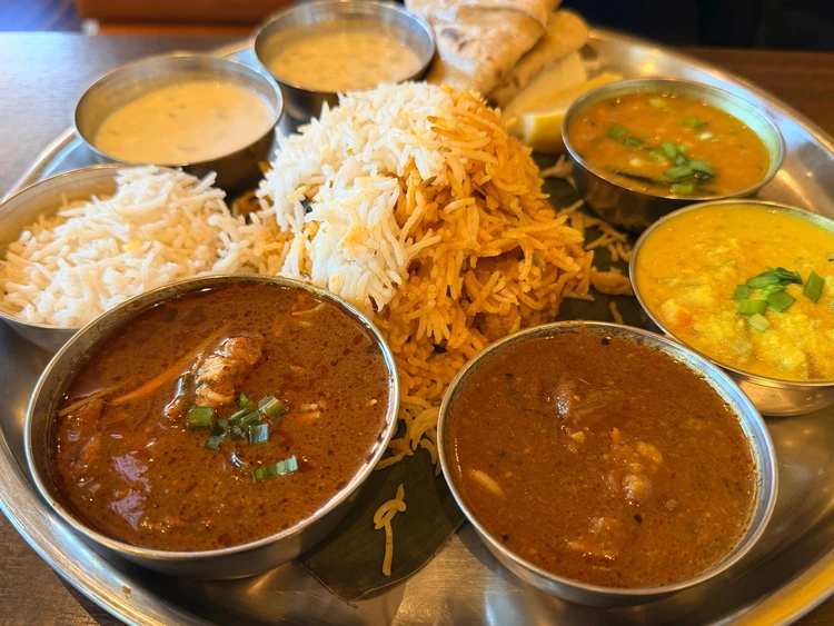 アーンドラ・ダイニング渋谷のメニューアーンドラ・ビリヤニ・ミールス。銀の皿の上にビリヤニやカレーが乗っている。