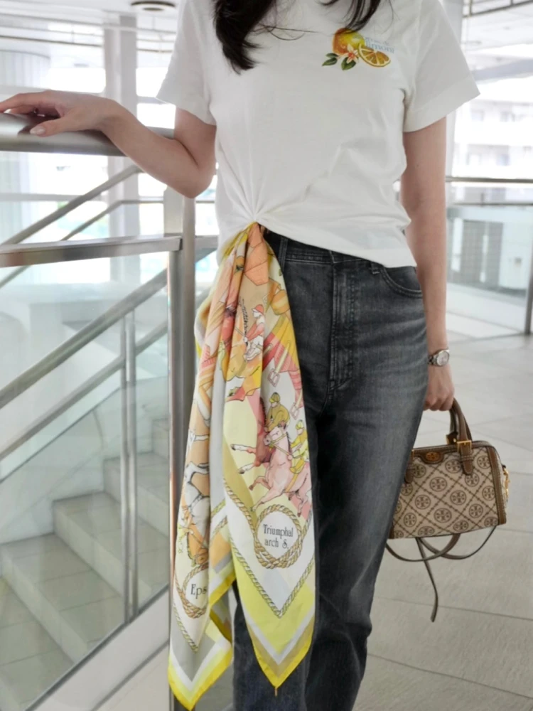 白Tシャツにイエロー系スカーフを結び、デニムとスニーカーを合わせたカジュアルコーデ