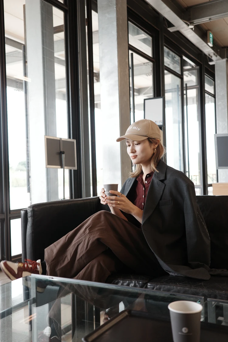 CITYSHOPのグレージャケットを取り入れた旅スタイル。ニットスカートやファーバッグと合わせたリラックスモードコーデ。