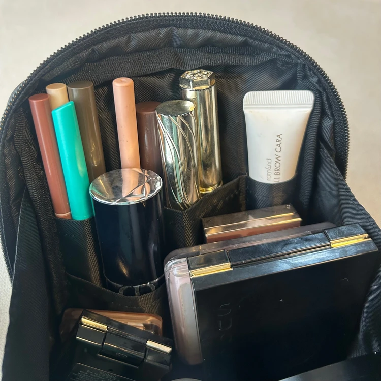 無印良品のナイロンメイクポーチをあけている。