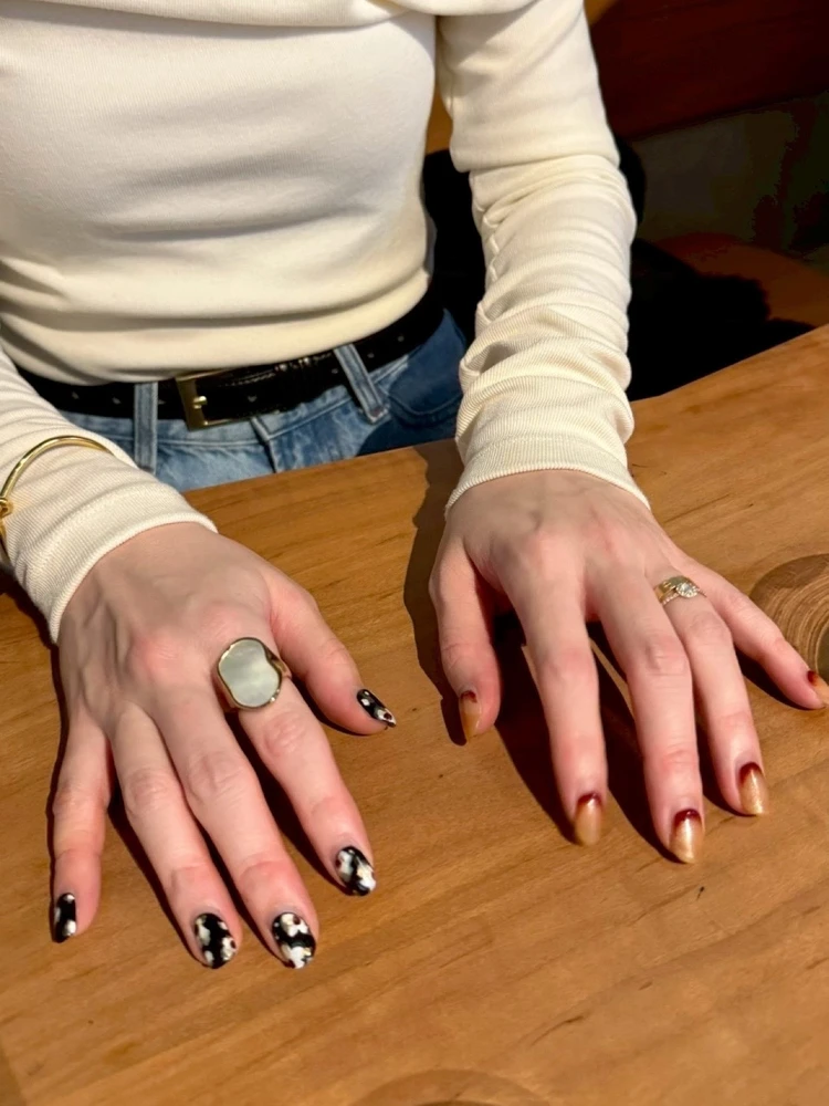 30代女性の冬ネイル。左右でデザインを変えた大人のちぐはぐネイルをブラックとブラウンでまとめたデザイン。