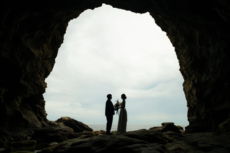 城ヶ島の海辺で向き合う新郎新婦のシルエットフォト