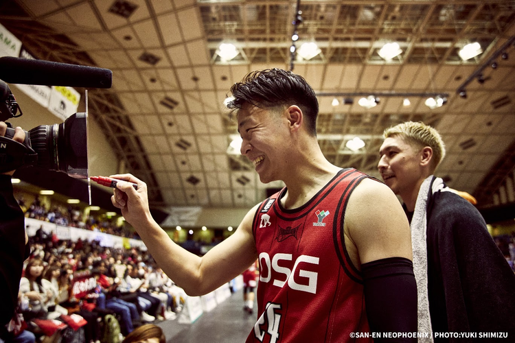 試合後、カメラに向かって笑顔でサインをする佐々木選手。隣には山内選手（2024-25シーズン）