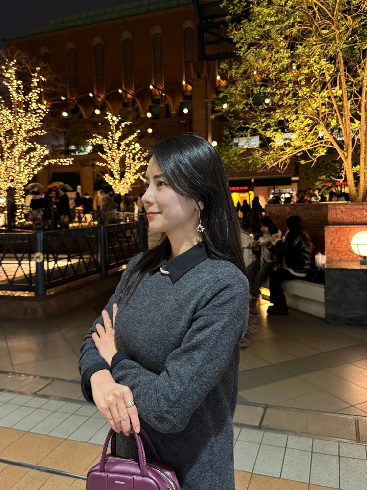 イルミネーション前で写真を撮る30代女性の写真