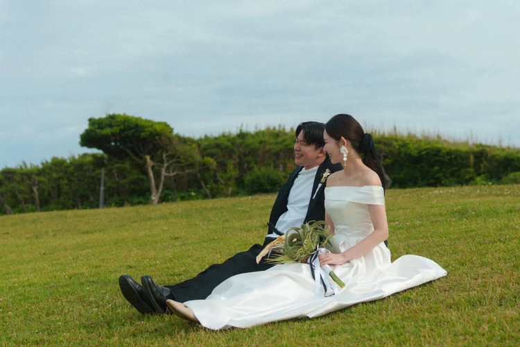 城ヶ島公園の芝生エリアに座る新郎新婦