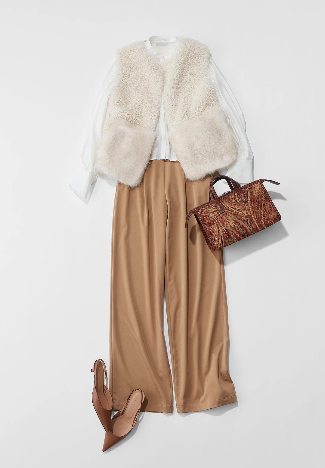 繊細な光沢を帯びたパンツとフワフワのフェイクファージレ