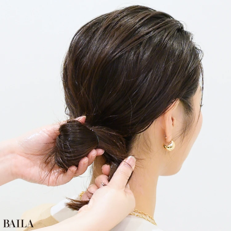 藤川美央さん シニヨンを仕上げます。  毛先をねじり、結んだゴムの上に巻きつけます。