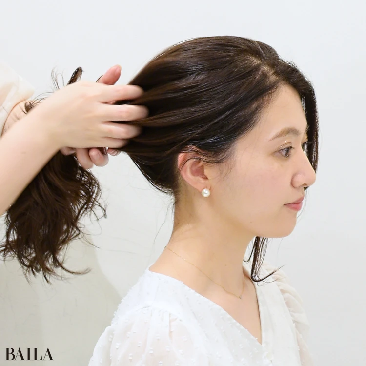 大野みおさん 指を大きく広げ、手ぐしでざっくりとひとつにまとめます。顔回りの髪は残して、垂らしておきます。