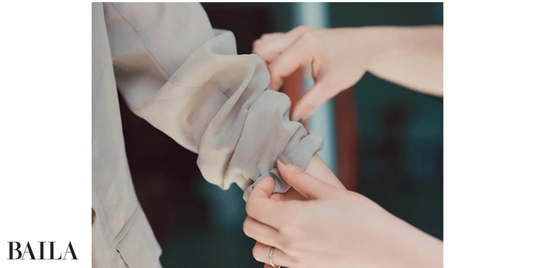 《2》袖口をゴムごとひじの下のあたりまで上げる。このとき、きれいに折りたたむのではなく、あえてくしゃっとラフにたくし上げるのがポイント