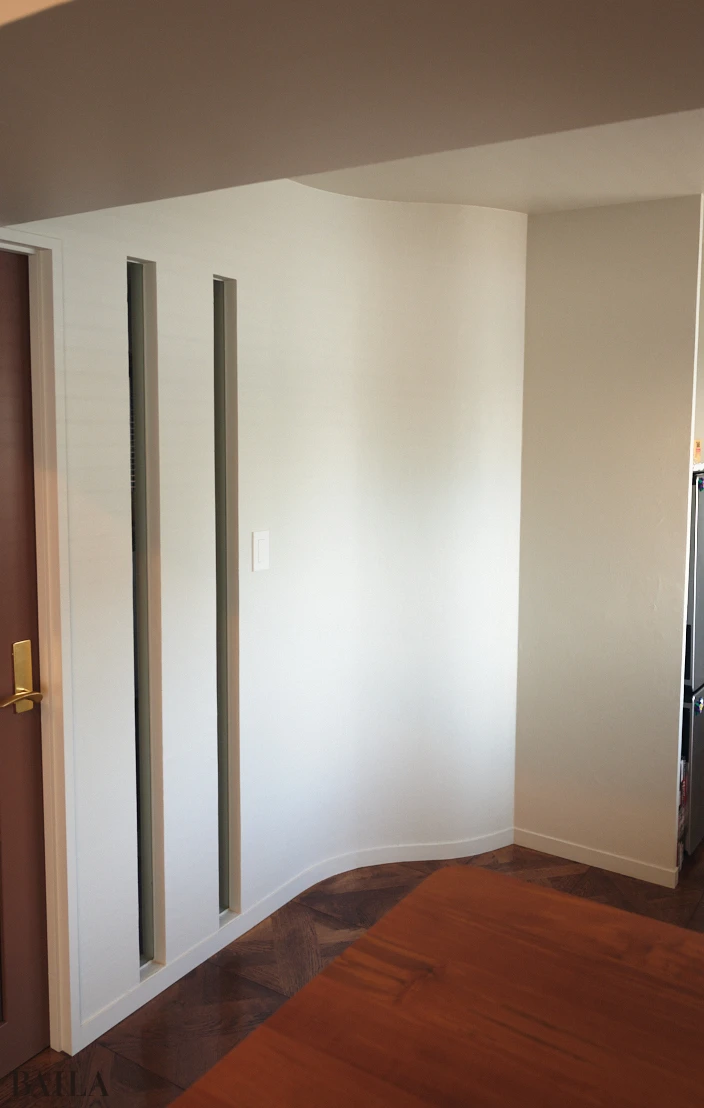 中古マンション　波打つ曲線と、玄関に光を取り込む彩光窓が美しい壁