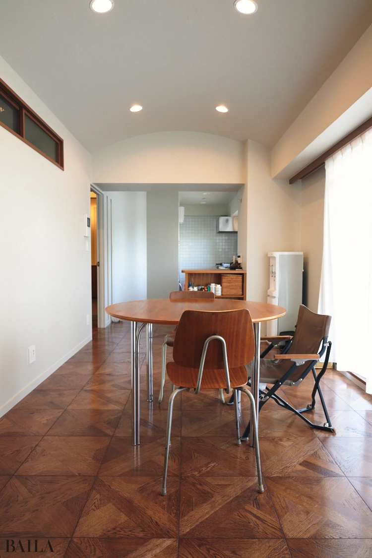 ブロックスクエアの床材にこだわりを感じる、ミッドセンチュリーテイストのリビングルーム。周囲の建物が低層のため、ベランダからの景色も広々と開放的。