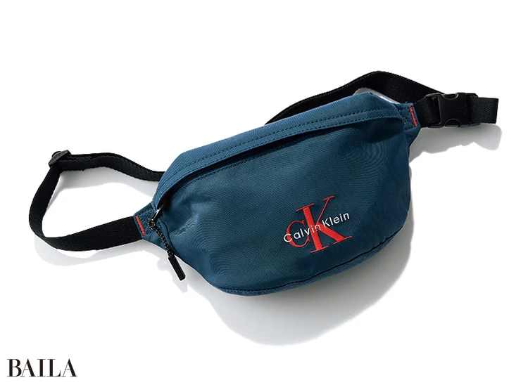 シックなネイビー基調のボディに、パキッと明るいオレンジのロゴがよく映える。水や汚れに強い ナイロン素材。（14×24×6.5）￥16500／カルバン・クライン カスタマーサービス（カルバン・クライン）