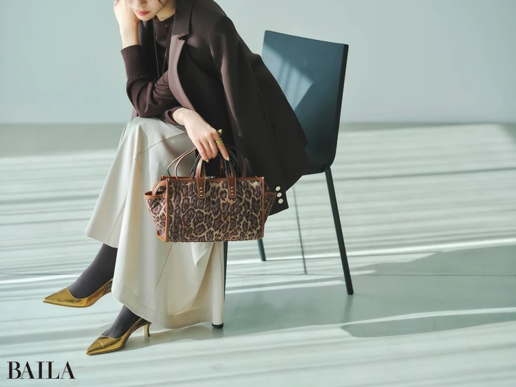 女子会コーデの足もとと手元の寄りカット ゴールドのパンプスとレオパード柄のバッグを持っている