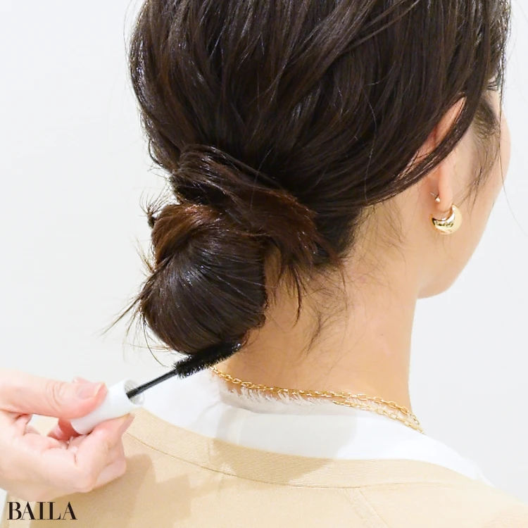 藤川美央さん シニヨンから飛び出す、ホワホワした毛をおさめるように、ヘア用のクリアマスカラで、シニヨンの上をなでていきます。毛流れに沿ってなでつけるような気持ちで。