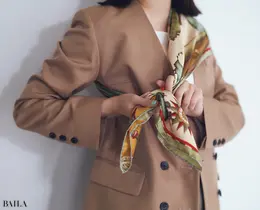 1と同じく三角に折ったスカーフを片方の肩をおおうようにかけ、両端をわきの下で結ぶ。ジャケットのボタンは開け、抜け感を出すのも忘れずに。