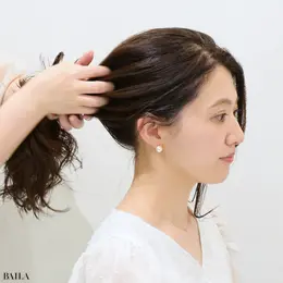 大野みおさん 指を大きく広げ、手ぐしでざっくりとひとつにまとめます。顔回りの髪は残して、垂らしておきます。