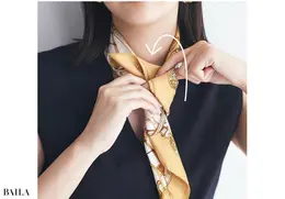 細くたたんだスカーフを首の前でクロス。そのまま上側Aを下側Bに巻きつけるように、後ろから一周させる。