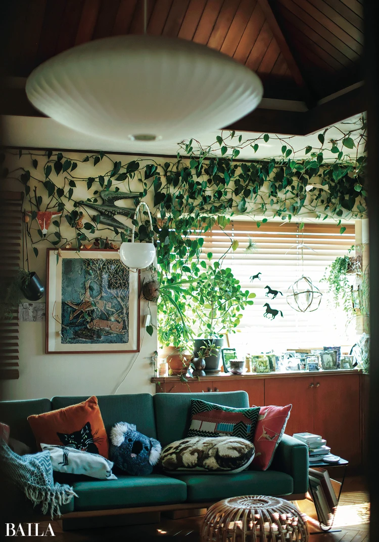 自然光がたっぷりと差し込むリビングは壁に這わせたつるや須藤さんが惚れ込んだアート、クッションでにぎやかに埋め尽くされている。