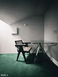 グリーンのじゅうたんで遊び心をのぞかせたという屋根裏のワークスペース。ガラスのテーブルは「エンツォ・マーリ」