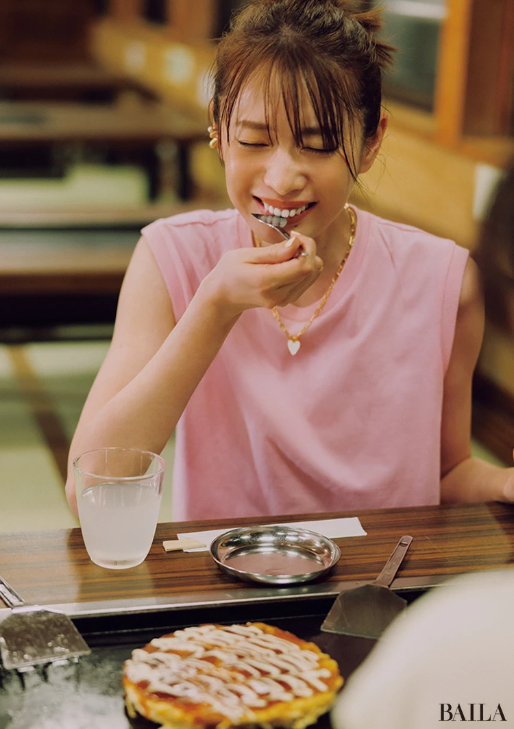 顔色を明るく仕上げるピンクに黒ベースの花柄スカートで緩急を