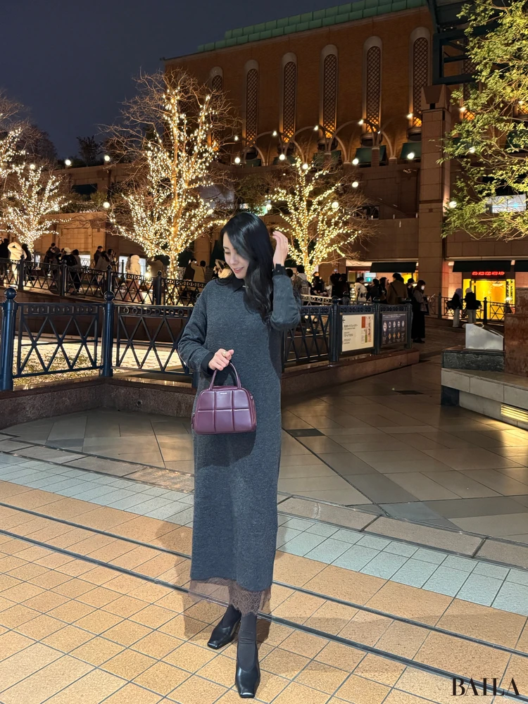 イルミネーション前で写真を撮る30代女性の写真