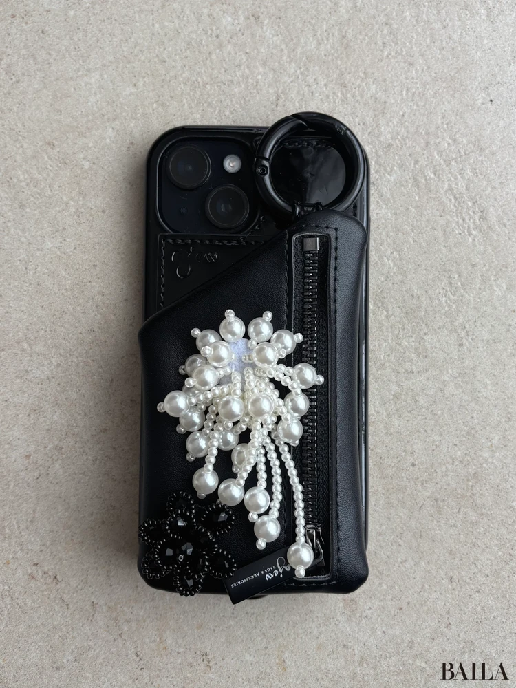 スマホケースにパールと黒い花のパーツをつけた様子