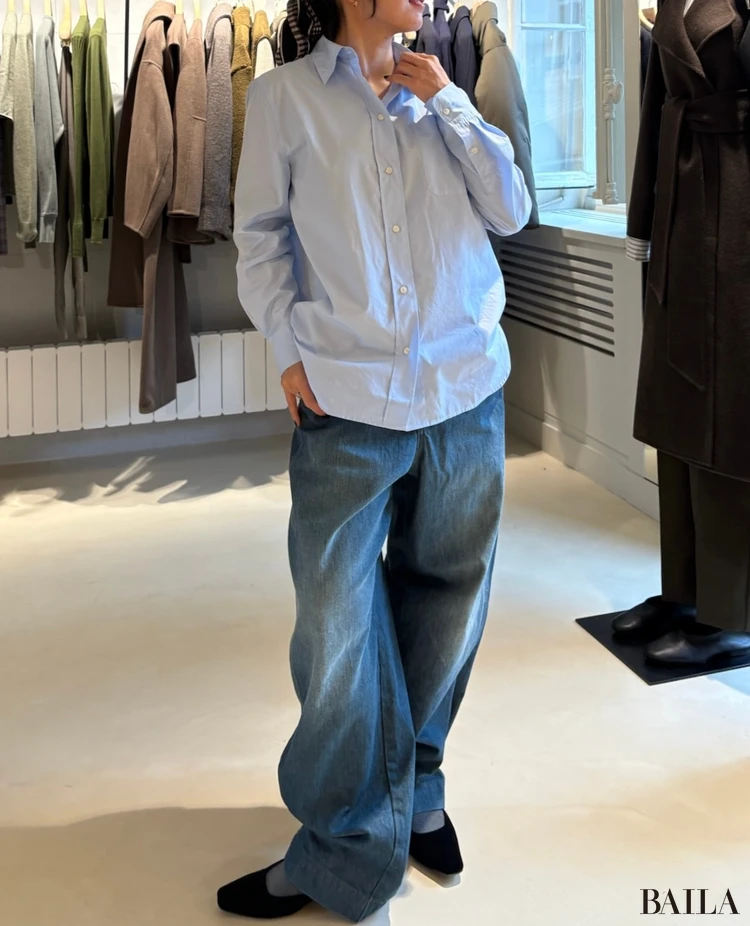 スールのブルーシャツとデニムを試着する様子