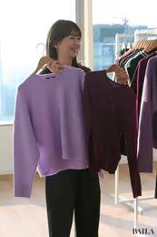 ユニクロの新作ワイン・パープルのニットを持つ真知さん